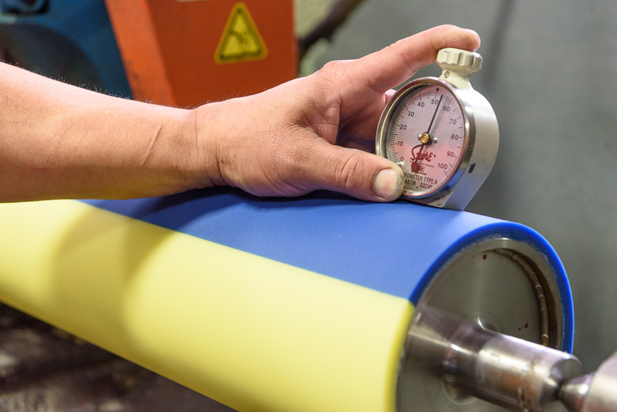 A UI technician checks the durometer of a special dual-color roller, to ensure that it meets the exacting tolerances.